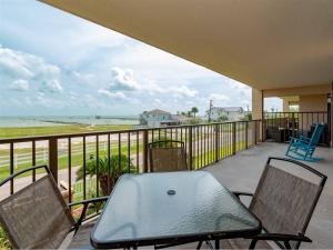 a balcony with a table and chairs and the ocean at Laguna Reef #214 - Retreat on Rockport Bay in Rockport