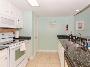 a kitchen with white cabinets and a sink at Laguna Reef #214 - Retreat on Rockport Bay in Rockport +27 photos