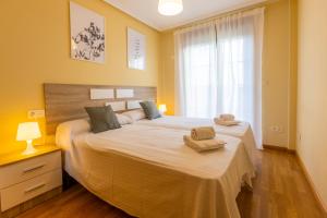 - une chambre avec un grand lit et 2 serviettes dans l'établissement Apartagal-Costa Reinante Spa, à Barreiros