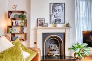a living room with a fireplace with a portrait of a man at DUDLEY - 1Bed - CORPORATE TRAVEL - PARKING - LONG STAYS in Dudley