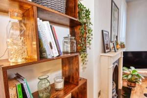 a wooden book shelf with books and candles at DUDLEY - 1Bed - CORPORATE TRAVEL - PARKING - LONG STAYS in Dudley