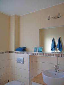 W łazience znajduje się umywalka i lustro. w obiekcie Pferdestall w mieście Grömitz