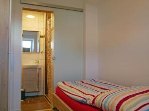 una camera con un letto e uno specchio accanto a un lavandino di Pferdestall a Grömitz