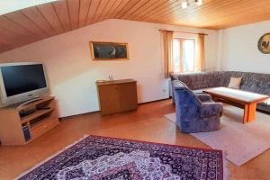 - un salon avec un canapé et une télévision dans l'établissement Ferienwohnung Schäffer, à Aschau im Chiemgau