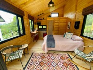 1 dormitorio con 1 cama en una cabaña de madera en El Hostel Granjero, en Sesquilé