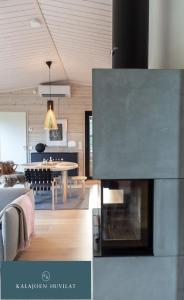 ein Wohnzimmer und ein Esszimmer mit einem Kamin in der Unterkunft Hirsihuvila Villa Letto, pihasauna & ulkoporeamme in Kalajoki