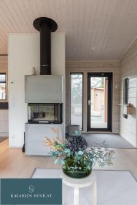 a living room with a vase of flowers on a table at Hirsihuvila Villa Letto, pihasauna & ulkoporeamme in Kalajoki