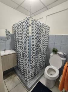 uma casa de banho com um WC e uma cortina de chuveiro em MALIBU HOUSE 