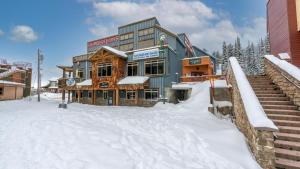 ein großes Gebäude im Schnee davor in der Unterkunft I Spy - Cozy Pet Friendly, Ski In Ski Out Condo with Private Hot Tub in Big White