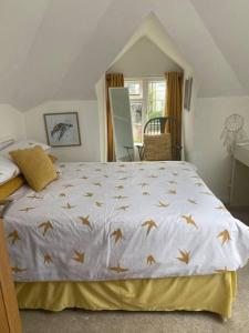 a bedroom with a bed with gold birds on it at Pet friendly unique 4-Bed Bungalow in Porthcawl in Porthcawl