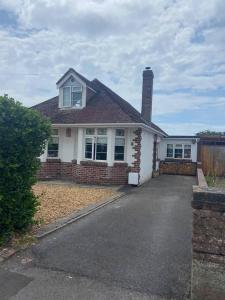 a white house with a chimney and a driveway at Pet friendly unique 4-Bed Bungalow in Porthcawl in Porthcawl