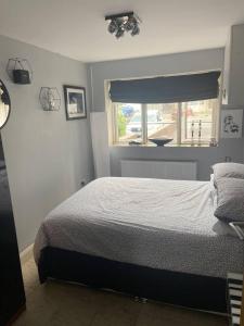a bedroom with a bed and a window at Pet friendly unique 4-Bed Bungalow in Porthcawl in Porthcawl