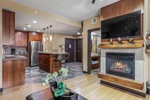uma sala de estar com lareira e televisão em Luxurious Condo with Spa, Steam Room hosted by Fenwick Vacation Rentals em Canmore