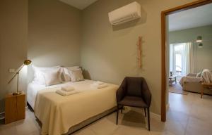 sypialnia z białym łóżkiem i krzesłem w obiekcie Casa Margô w Lagosie