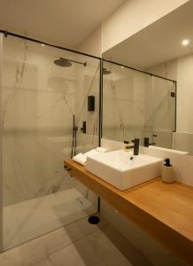 a bathroom with a white sink and a shower at Casa Margô in Lagos