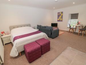 Cornhill-on-tweed的住宿－Cherry Studio，一间卧室配有一张大床和一张沙发