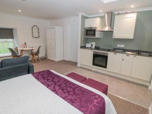 a bedroom with a large bed and a kitchen at Cherry Studio in Cornhill-on-tweed