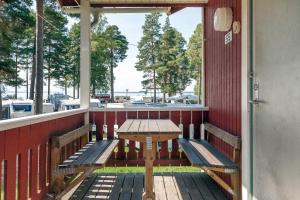 a porch with two benches and a table on it at First Camp Siljansbadet - Rättvik in Rättvik