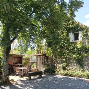 een huis met een picknicktafel en een boom bij Gîte Normand Le Merle blanc 2 à 6 personnes 