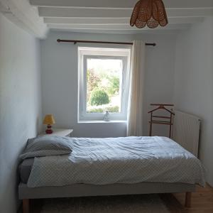 - une chambre avec un lit et une fenêtre dans l'établissement Gîte Normand Le Merle blanc 2 à 6 personnes, 