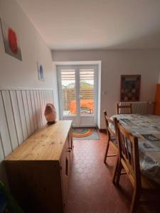 uma sala de jantar com uma mesa e cadeiras e uma janela em Gîte Normand Le Merle blanc 2 à 6 personnes 