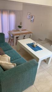 sala de estar con sofá y mesa en De La Lisa Triplex hasta 6 personas en Pinamar