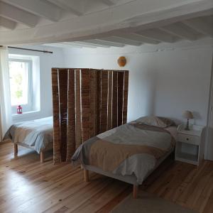 een slaapkamer met 2 bedden en een raam bij Gîte Normand Le Merle blanc 2 à 6 personnes 