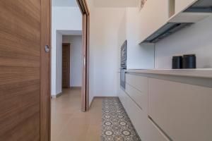 a kitchen with white walls and a wooden door at white moon holiday home in Ostuni +30 photos