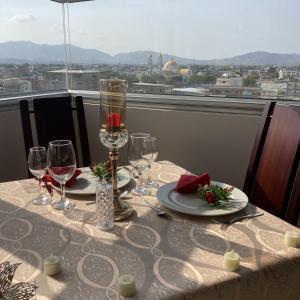 a table with wine glasses and a view of the city at Hotel Ceibo Dorado in Portoviejo