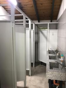 un baño con una fila de puestos en una habitación en Lapacho Hostel Salta Coliving en Salta