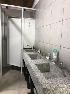 uma fila de três lavatórios numa casa de banho pública em Lapacho Hostel Salta Coliving em Salta