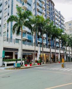 uma rua vazia com palmeiras em frente a um edifício em 2F Newport Condotel em Manila