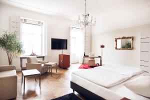 uma sala de estar branca com uma cama e um sofá em Hotel Weitzer Graz - Centre of Graz em Graz