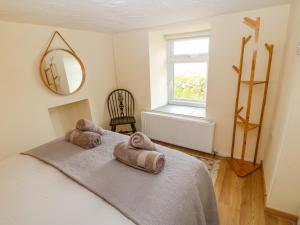 a bedroom with a bed with towels on it at Bryn Derwen in Caernarfon