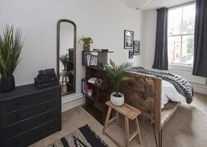 a bedroom with a bed and a dresser and a mirror at DUDLEY 2-BED Luxury - Spacious - Parking in Dudley