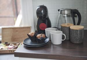 a table with cups of coffee and a plate of muffins at DUDLEY 2-BED Luxury - Spacious - Parking in Dudley