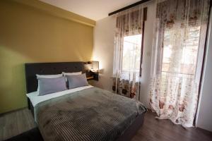 a bedroom with a bed and a window with curtains at Angelina Apartment in Bitola
