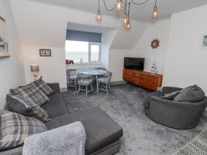 a living room with a couch and a tv and a table at Sea Spell Loft in Hornsea