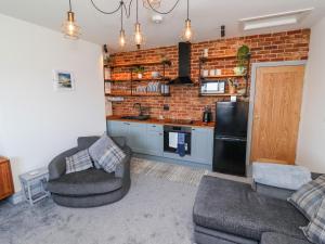 a living room with two chairs and a kitchen at Sea Spell Loft in Hornsea
