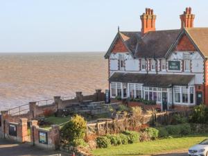 a house on the beach with the ocean behind it at Sea Spell Loft in Hornsea