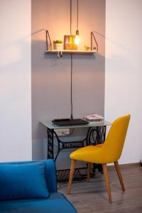 a table and a yellow chair in a room at Angelina Apartment in Bitola