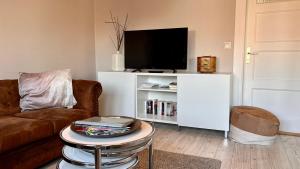 ein Wohnzimmer mit einem TV auf einem weißen Schrank in der Unterkunft Haus MeerZeit Whg.2 in Cuxhaven