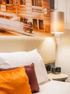 a bedroom with a bed and a clock on a table at Hotel Indigo Madrid - Gran Vía by IHG in Madrid