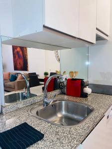 a kitchen counter with a sink and a living room at Madrid Citymad Six in Madrid