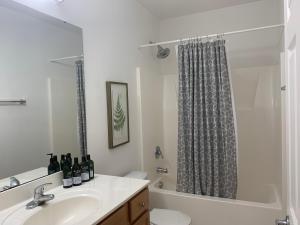 a bathroom with a sink and a shower curtain at The Popular Pad in Downtown Raleigh, NC in Raleigh