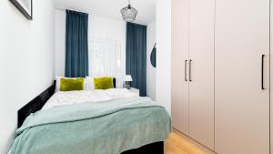 1 dormitorio con 1 cama con manta verde y blanca en Apartamenty Sun & Snow Słowackiego, en Karpacz