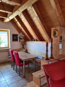 a dining room with a wooden table and red chairs at Ferienwohnung Helga in Thalmässing