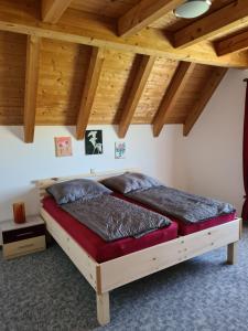 a bed in a room with wooden ceilings at Ferienwohnung Helga in Thalmässing