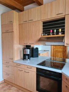 a kitchen with wooden cabinets and a black appliance at Ferienwohnung Helga in Thalmässing