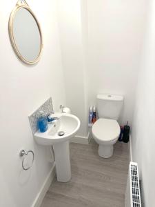 a white bathroom with a sink and a toilet at Thorpe House - Home Crowd Luxury Apartments in Doncaster